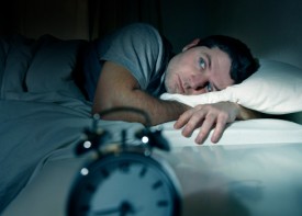Man in bed suffering from insomnia