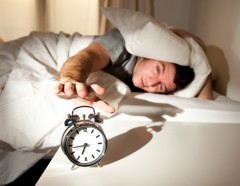 Sleeping man disturbed by alarm clock